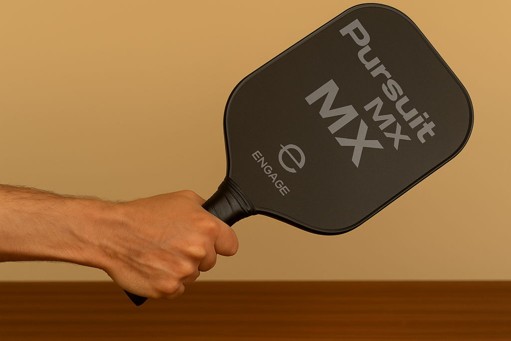 Hand holding Engage Pursuit MX paddle showing ergonomic octagonal grip.